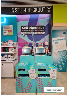 Self-checkout counters at Watsons Singapore, featuring payment options and recycling bins.