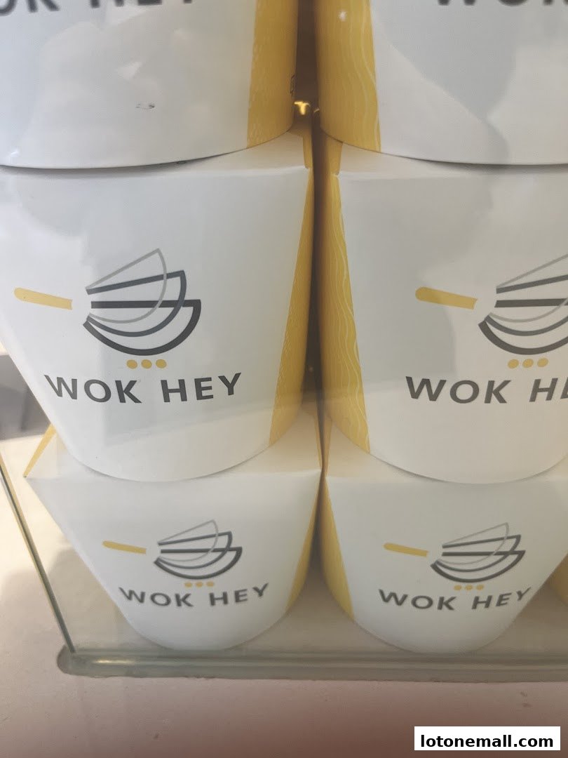Stacked white containers with the WOK HEY logo and yellow accents.