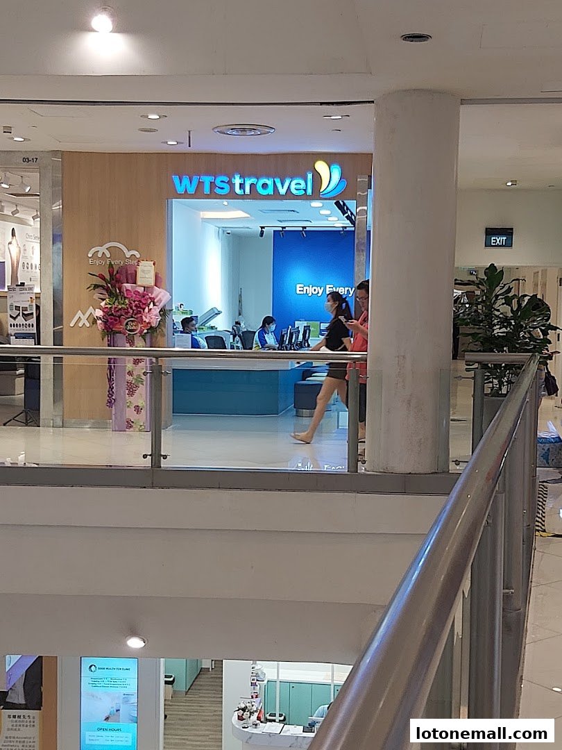 The WTS Travel & Tours shop front with staff serving customers and floral decorations.