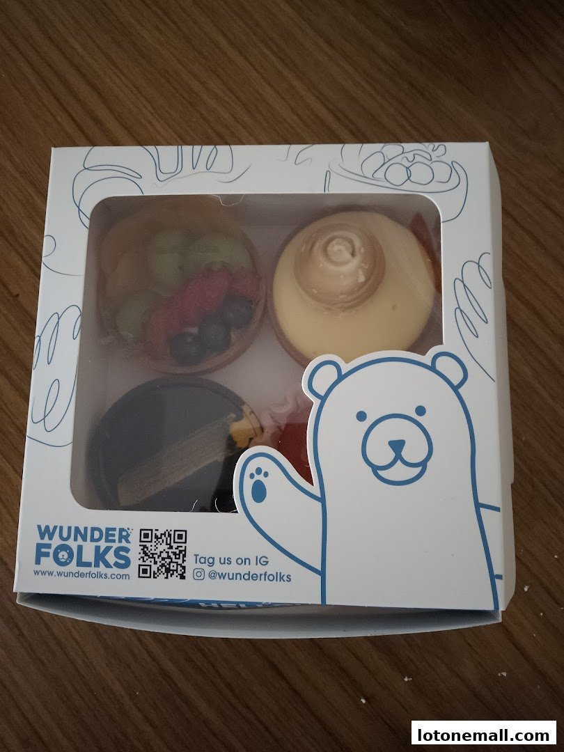A box of four assorted tarts from Wunderfolks, featuring fruit, meringue, and chocolate.
