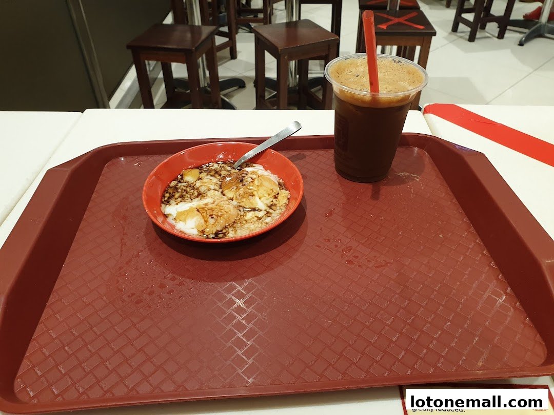 A tray with a bowl of soft-boiled eggs and a drink at Ya Kun Kaya Toast.