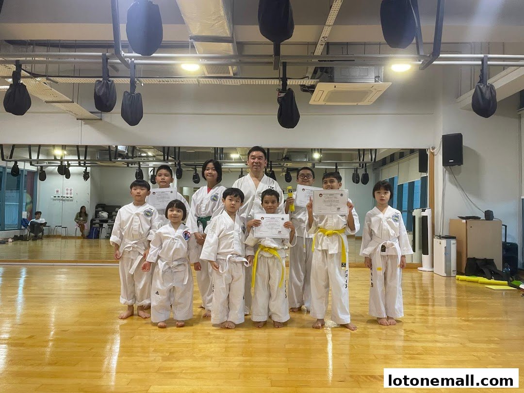 A group of children and an instructor in a martial arts studio, holding certificates.