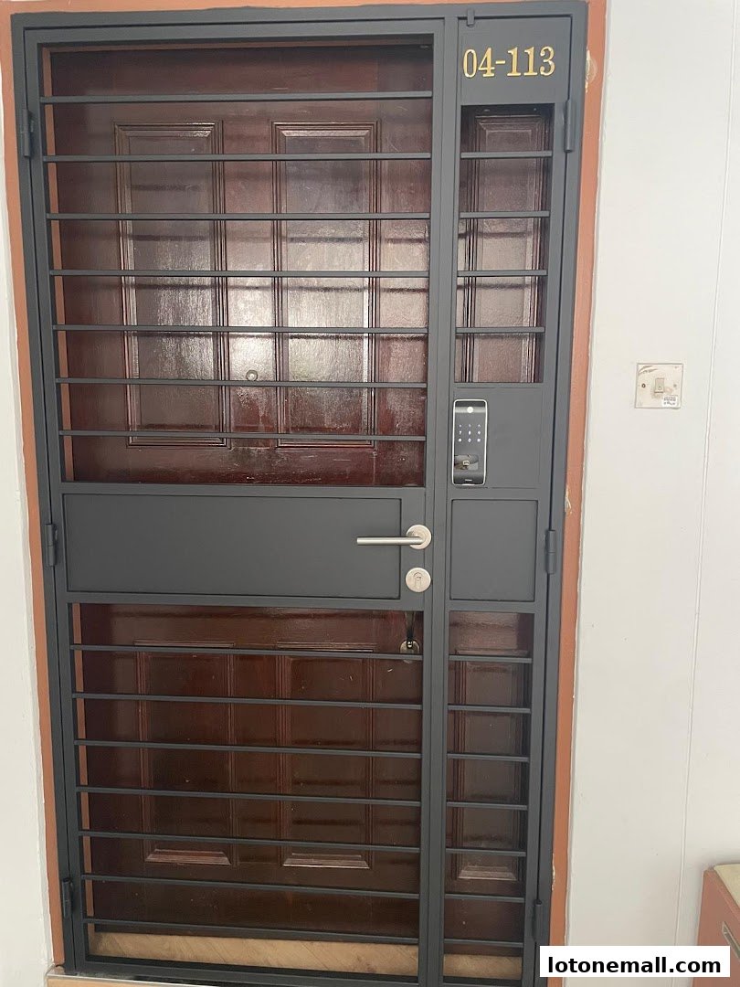 A modern metal gate with a digital lock and unit number 04-113.