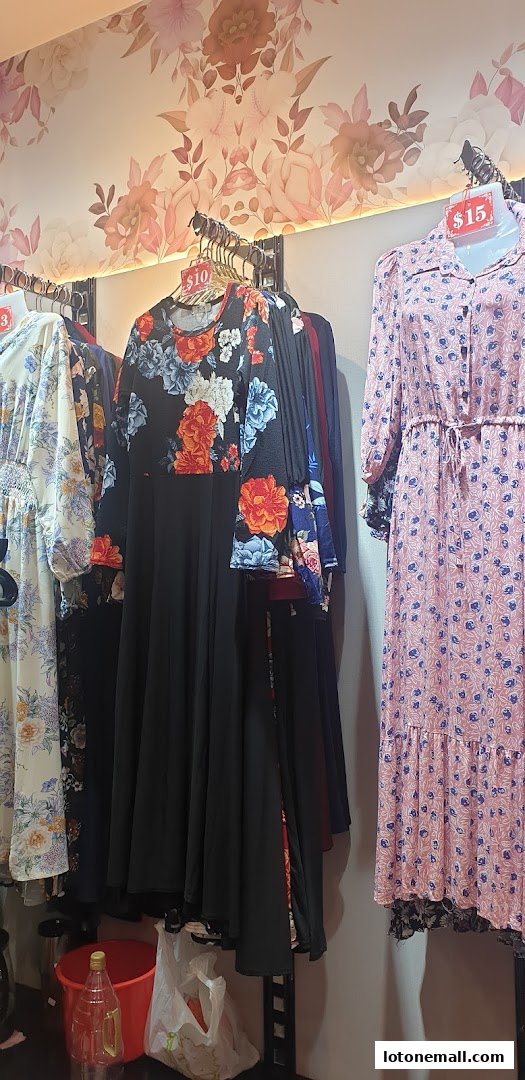A selection of floral print dresses displayed on hangers in a shop.