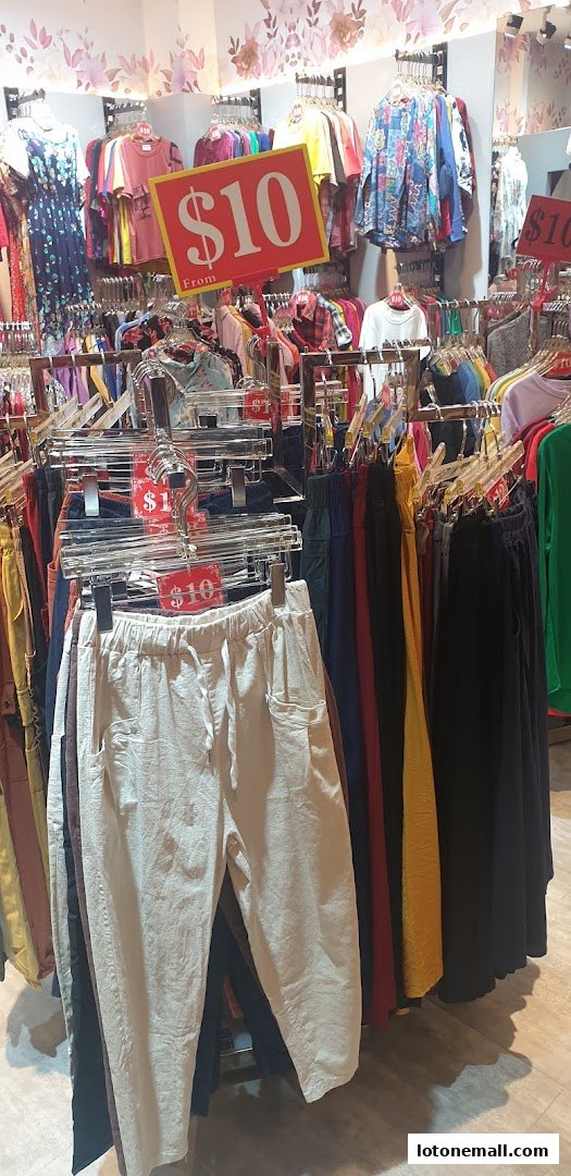A clothing store interior with racks of colorful apparel and prominent '$10' price signs.