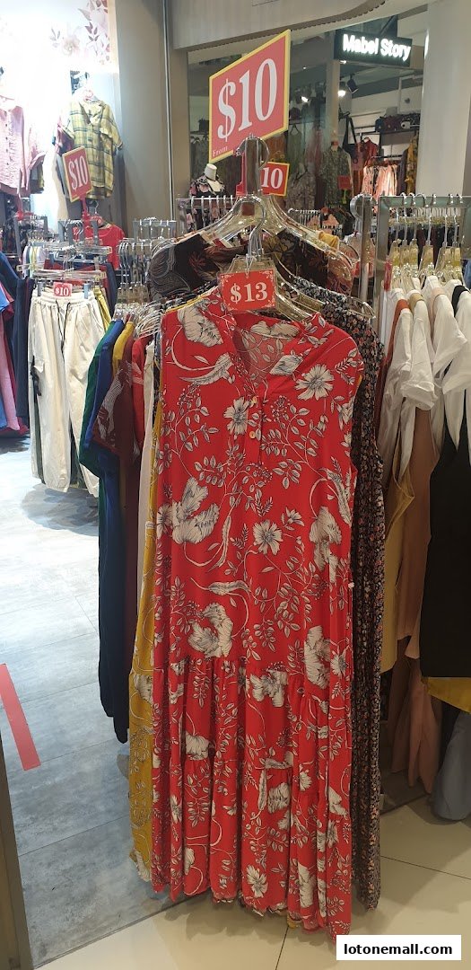 A rack of colorful women's clothing with price tags displayed.