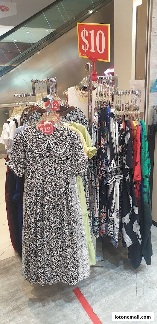 A display of floral print dresses and other clothing items on racks with price tags.