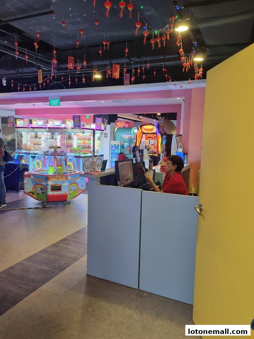 An arcade with claw machines and other games, decorated with red lanterns.