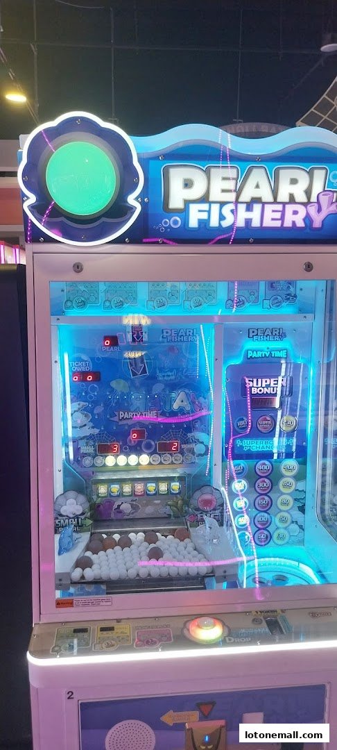 A brightly lit arcade game machine called 'Pearl Fishery' with colorful lights and prizes.