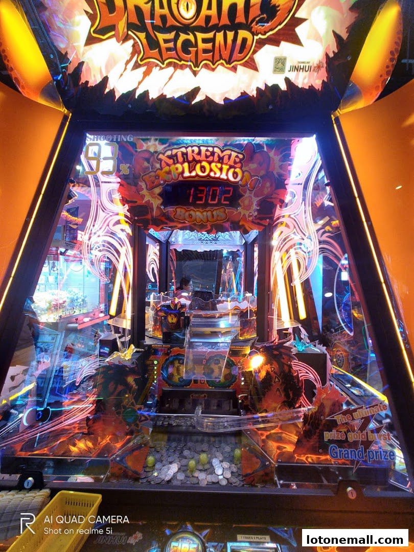 An illuminated arcade game machine with a dragon theme and a coin-operated play area.