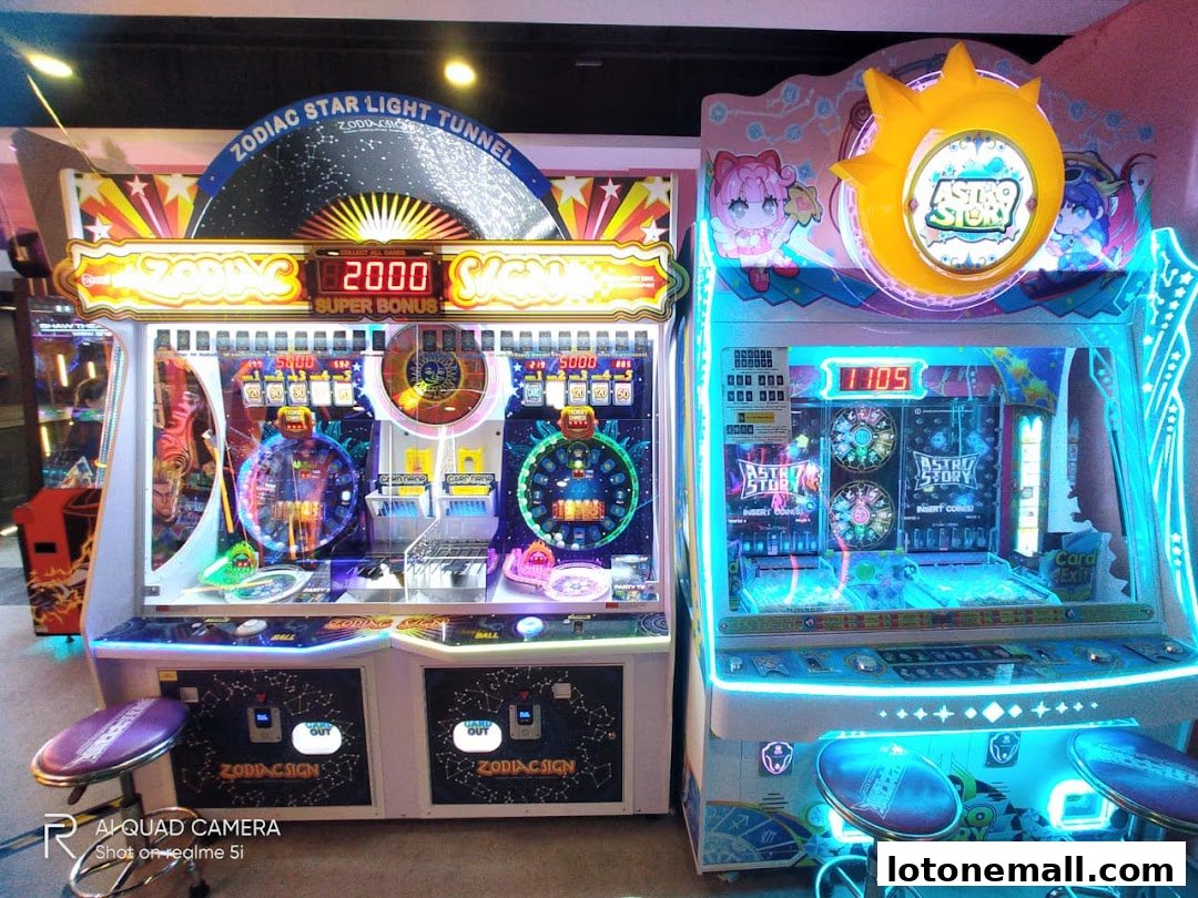 Two brightly lit arcade machines, one themed 'Zodiac Star Light Tunnel' and the other 'Astro Story'.