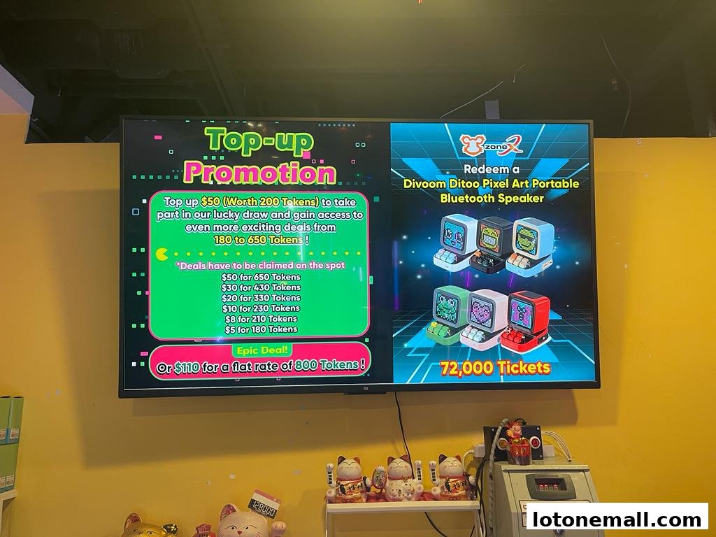 A screen displays a top-up promotion and a Divoom speaker redemption offer at Zone X.